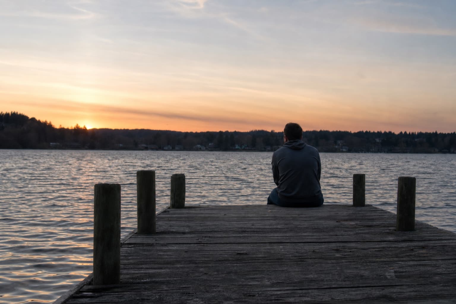 Persona sola en un embarcadero al atardecer